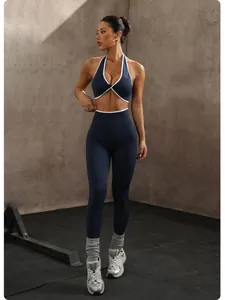 Modella che indossa set yoga blu navy senza cuciture con profili bianchi e reggiseno