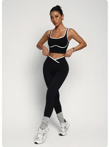 Completo fitness nero con profili bianchi e leggings a vita alta incrociati su modella