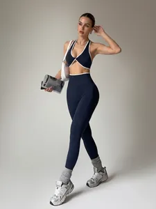 Completo yoga blu navy senza cuciture con profili bianchi, reggiseno sportivo e leggings