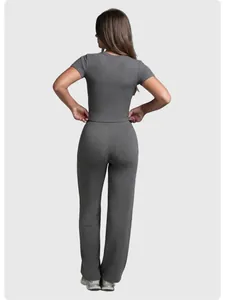 Back view of a woman wearing a grey short-sleeve top and matching straight-leg yoga pants