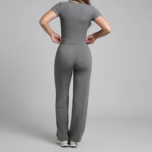 Women's grey two-piece yoga set featuring a short sleeve top and straight leg pants