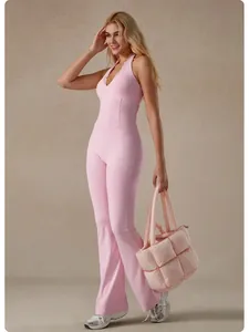 Full body view of pink lace V-neck yoga jumpsuit with flared pants and padded bag