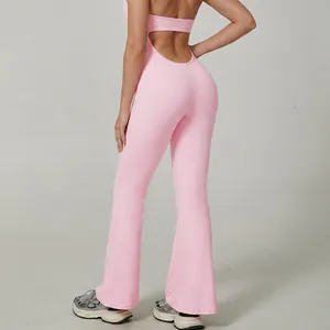 Pink backless halter yoga jumpsuit with flared pants showing the backless design details
