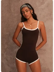 Detailed view of two-piece brown yoga set with white trim on a model.