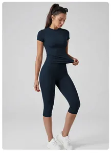 Woman wearing navy blue high-waist quick-dry yoga set with short sleeves and capri leggings