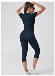 Back view of a woman in navy blue high-waist yoga set with short sleeves and capri leggings