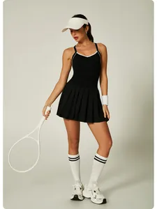 Full body shot of a woman in a black pleated tennis dress with white piping detail