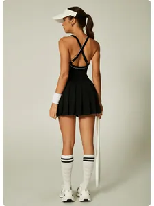 Back view of a black athletic tennis dress featuring cross straps and pleated skirt