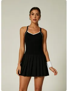 Full body view of a black one-piece tennis dress with white contrast trim and a pleated skirt