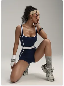 Close-up detail of navy blue contrast trim yoga romper on a model in a fitness studio pose