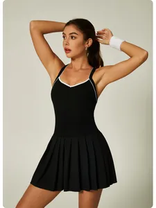 Detail view of a black pleated tennis dress with white contrast trim on a model