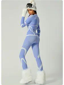 Purple and white patterned women's ski base layer set worn by a model in ski gear.