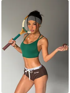 Detailed macro view of green sports bra and brown yoga shorts set worn by model