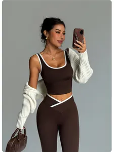 Close-up view of brown seamless yoga set featuring contrast white trim and a matching shrug