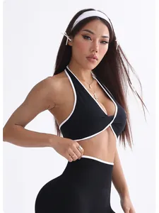 Nahaufnahme schwarzer Yoga-Sport-BH mit weißem Saum an einem weiblichen Fitnessmodel