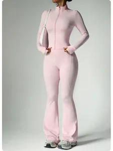 Two-piece pink yoga fitness set with long sleeve zipper jacket and flared athletic pants.
