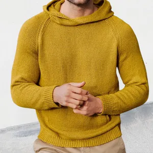 Detailansicht eines senfgelben Herren-Kapuzenpullovers aus Strick mit Raglanärmeln und Textur.