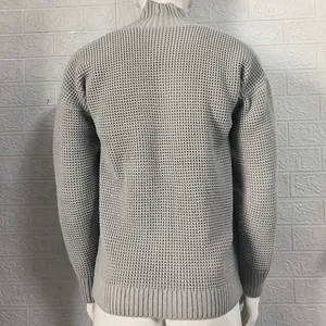 Rear view detail of grey knit sweater showing fabric texture and ribbed hem line