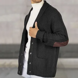 Detail showing the chunky knit texture and suede elbow patch on a black cardigan