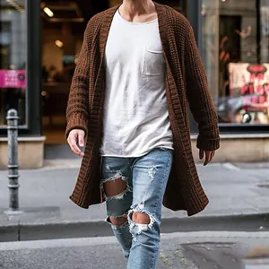 Close-up of a man wearing a long brown knitted cardigan over a white tee in urban street style