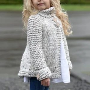 Detail van een grofgebreid vest voor kinderen met grote decoratieve houten knopen