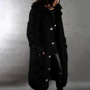 Close-up of a women's long chunky knit black cardigan with oversized light buttons.