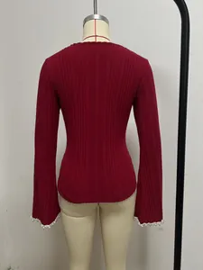 Vue arrière détaillée d'un haut en maille bordeaux avec poignets évasés et perles