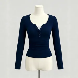Detail view of navy blue ribbed knit top with white lace splicing and Henley neck