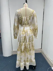 Rückansicht eines weißen Sets aus Crop-Top und Maxirock mit Blumenmuster auf einer Puppe.
