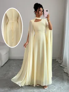 Detailed view of cream evening dress showing mock neck cutout and back tie detail.