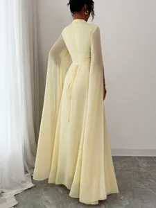 Detailed view of back lace-up design and cape sleeves on pale yellow gown