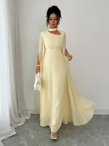Full-length view of an elegant cream party dress with sheer cape sleeves and cutout detail.