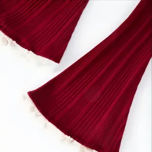 Vue détaillée des poignets en maille côtelée rouge avec bordure de perles blanches