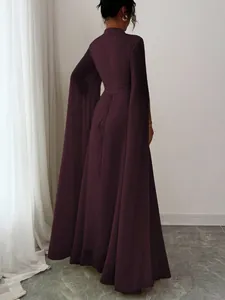 Back view of elegant dark purple evening gown featuring dramatic cape sleeves and lace-up detail