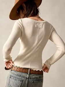 Elegant off-white long sleeve ribbed top with back bow and ruffled lettuce hem detail