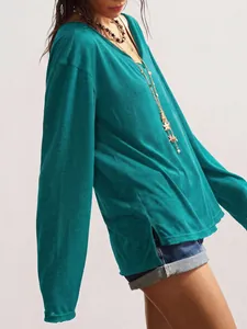 Détail d'un haut ample à manches longues et col en V pour femme en bleu canard avec fentes