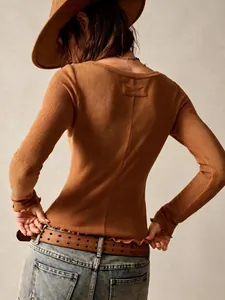 Back view of vintage brown slim fit long sleeve top with textured fabric and ruffled hem