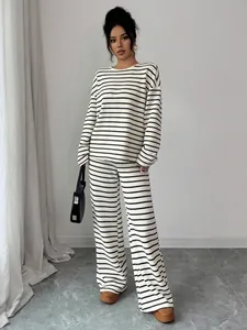 Chic black and white striped two-piece lounge set worn by a model in a minimal room