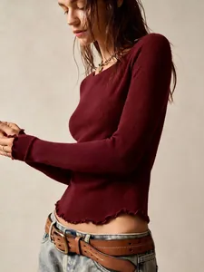 Close-up of vintage burgundy long sleeve top with textured fabric and ruffle lettuce hem