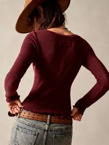 Back view detail of burgundy slim fit long sleeve top with textured fabric and lettuce hem