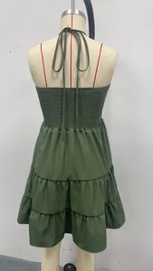 Detailed back view of a dark green tiered smocked halter mini dress for summer vacation