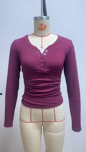 Dettaglio di una t-shirt a maniche lunghe a costine con scollo Henley color prugna
