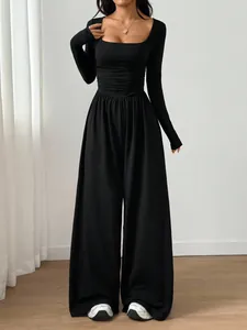 Sophisticated black long sleeve jumpsuit with a square neck and flattering wide leg silhouette