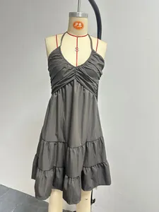 Close-up of a charcoal grey halter V-neck mini dress with tiered ruffle details