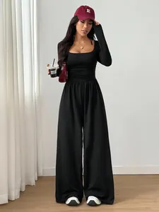 Elegant black long-sleeve square-neck wide-leg jumpsuit styled with accessories