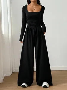Elegant black long-sleeved jumpsuit featuring a square neckline and wide-leg design