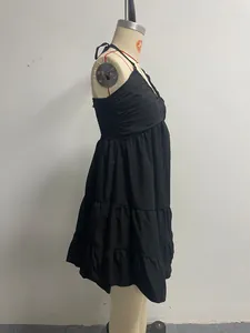 Detailed side view of black halter-neck tiered ruffle dress on a tailor mannequin
