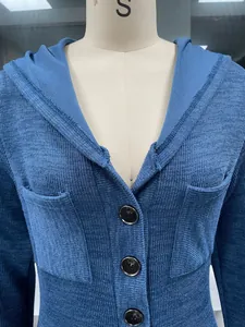 Close-up of blue hooded knit dress featuring dark buttons and functional pockets