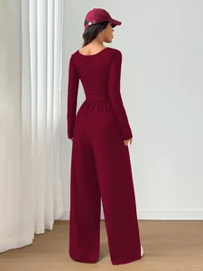 Back view of a stylish maroon long sleeve square neck wide leg jumpsuit with waist tie