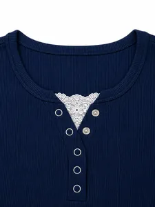 Dettaglio dello scollo di una t-shirt in maglia a coste blu con inserto in pizzo